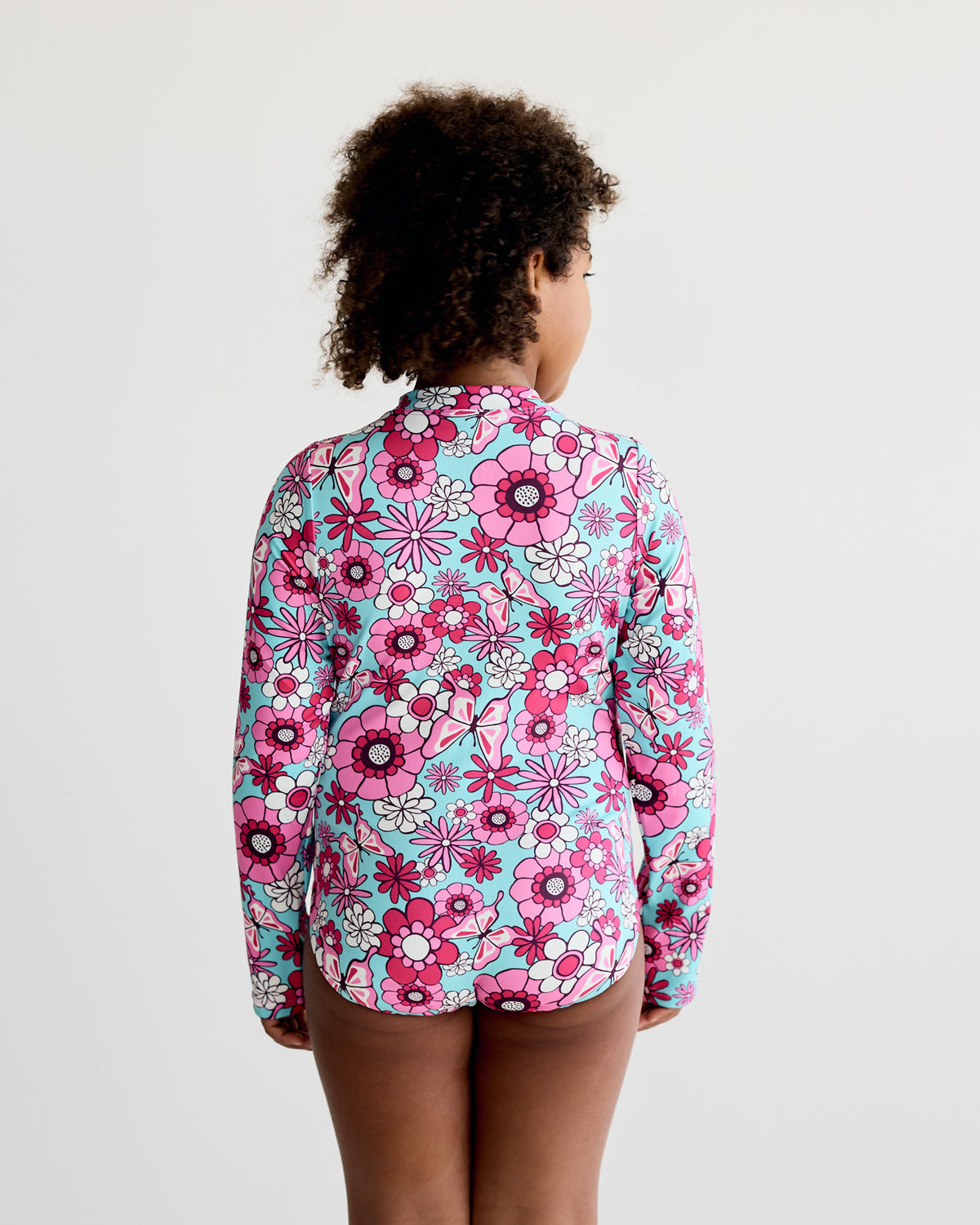 Pink White Floral, Flowers and Butterflies print on teal blue long-sleeve kids swimwear swimming costume with UPF50+ sun protection and nylon fabric.