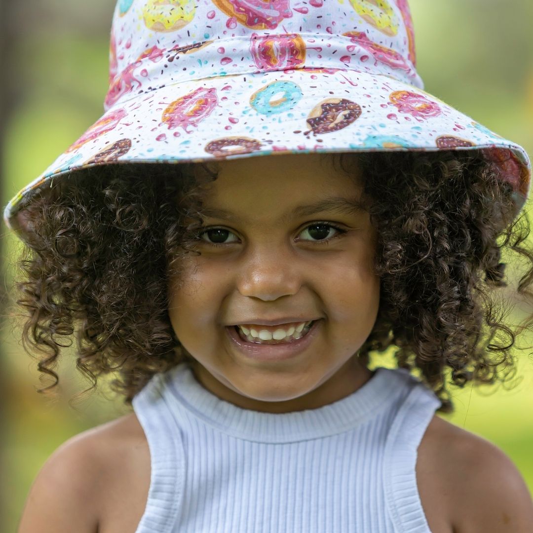 Kids Bright Fun Doughnuts Print Bucket Hat. Extra wide brim for sun protection. UPF50+ Adjustable strap.