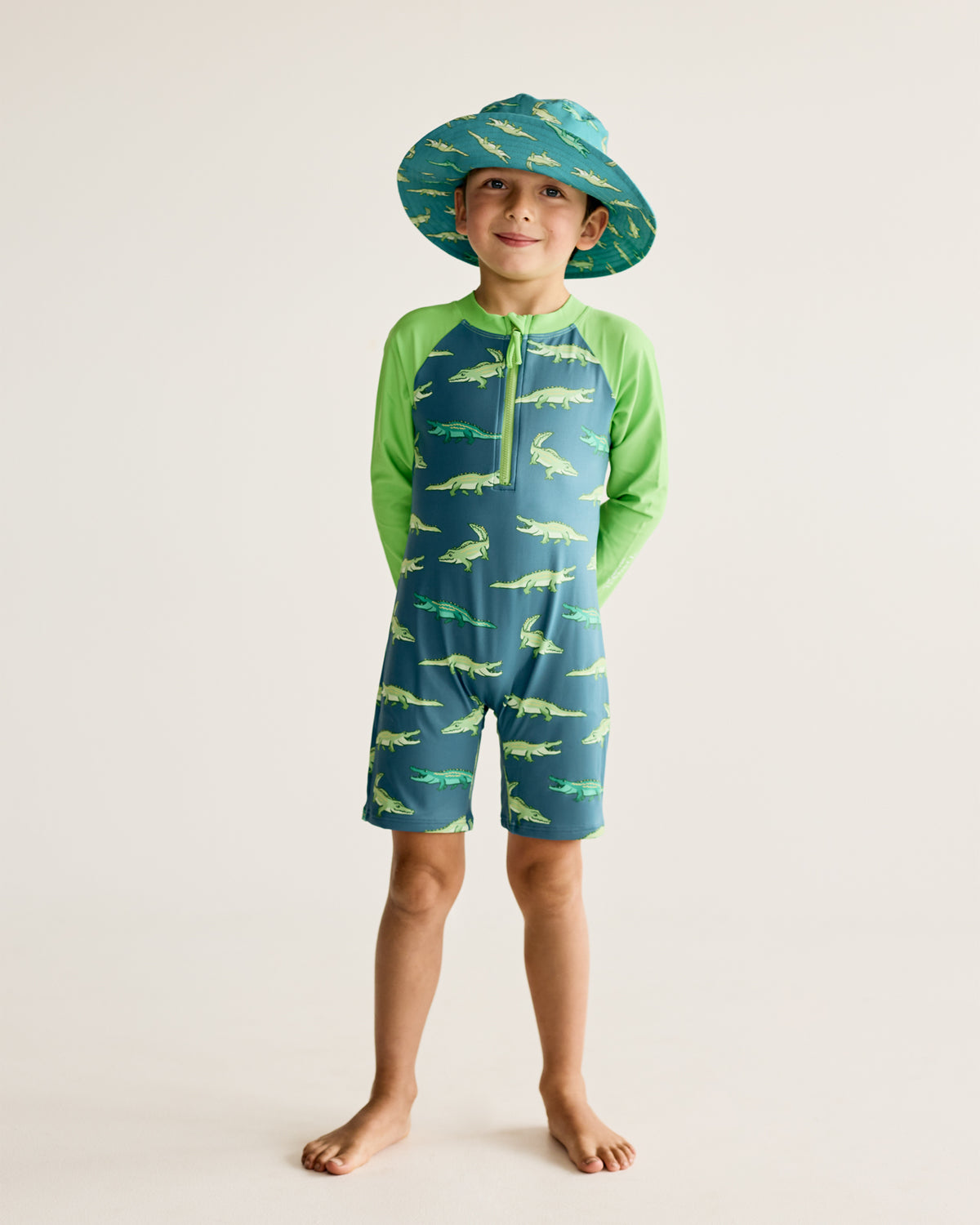 Crocodiles and Alligators print on dark green long-sleeve kids swimwear onesie, one-piece with UPF50+ sun protection and nylon fabric.