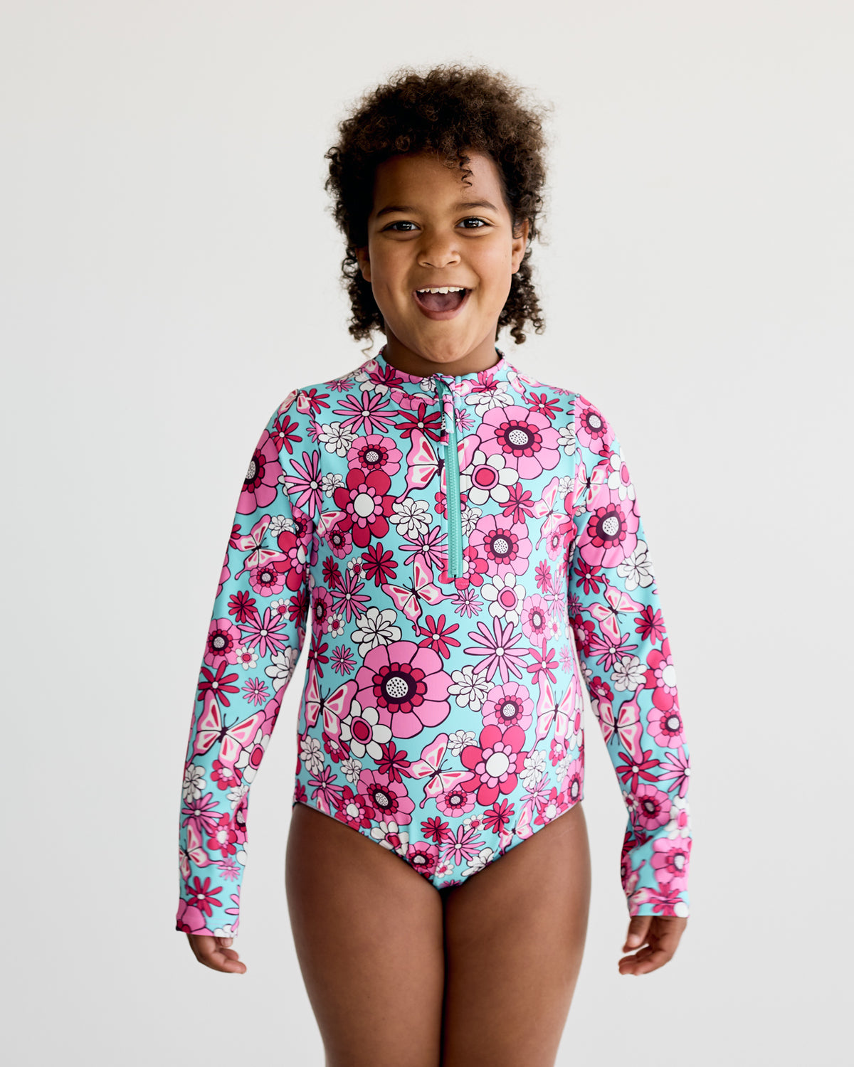 Pink White Floral, Flowers and Butterflies print on teal blue long-sleeve kids swimwear swimming costume with UPF50+ sun protection and nylon fabric.